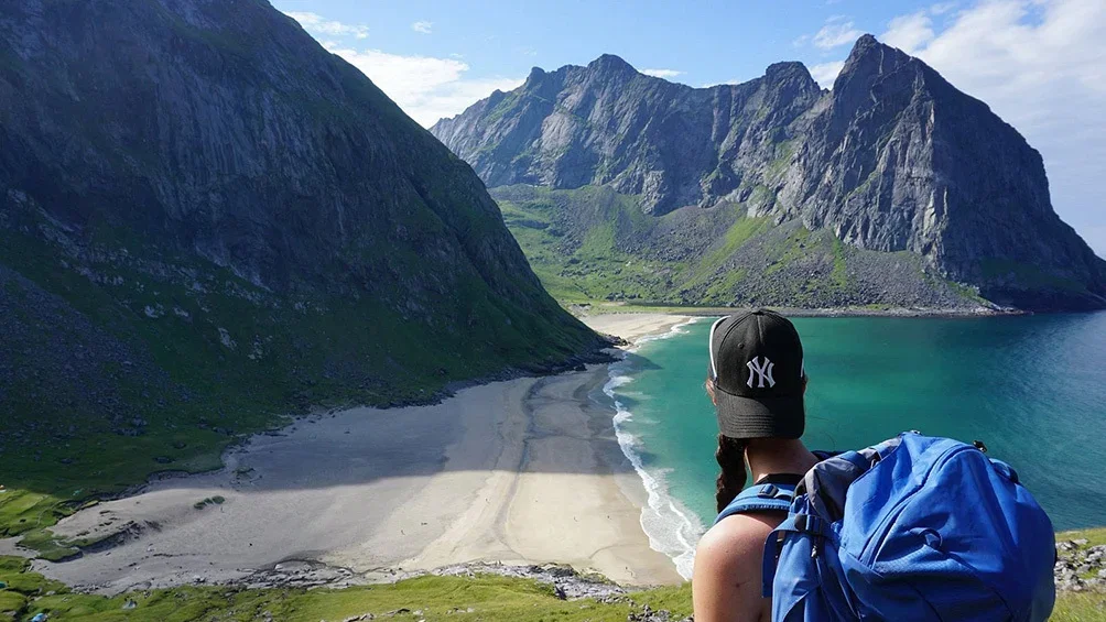 Image description: Hiker overlooking Kvalvika Beach in the Lofoten Islands.
