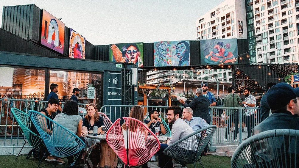Image description: A group of friends dining outside at Stackt market in Toronto.
