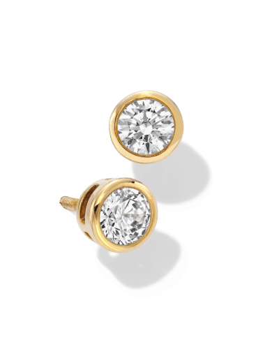 Yellow gold bezel-set diamond stud earrings.