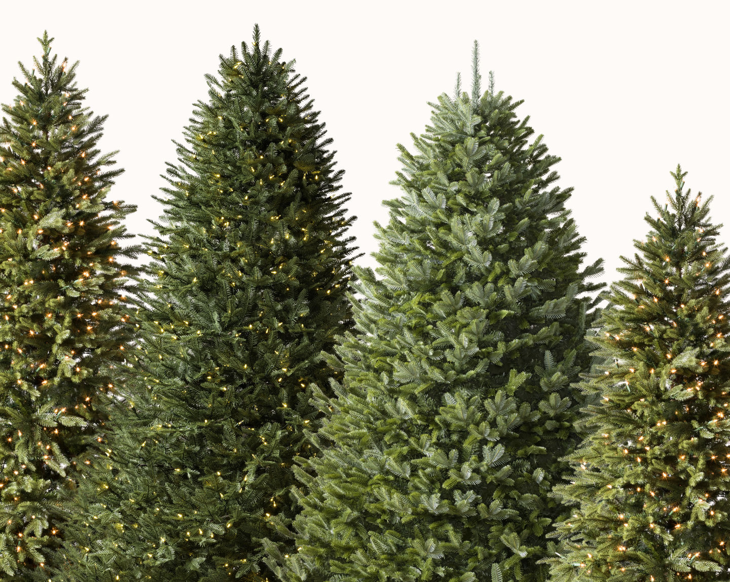 Group of artificial Christmas trees with different shapes, branch styles, and warm lights.