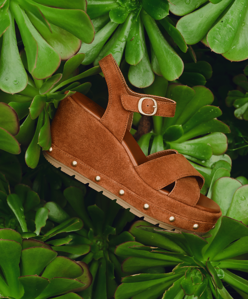 Sunpeak™ Wedge Ankle Strap RVT in Iced Tea & Gum photographed against plants