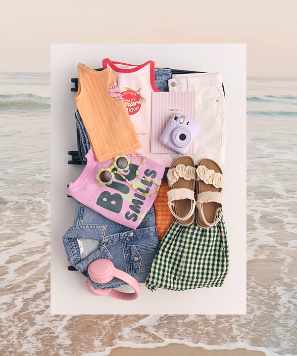 A selection of girls’ holiday clothing packed into a suitcase