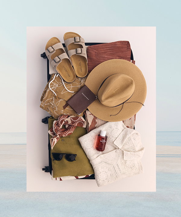 A selection of men's holiday clothing packed into a suitcase