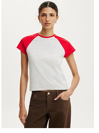 Woman wearing red and white raglan t-shirt and brown pants