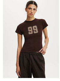 Woman wearing brown graphic t-shirt and black pants