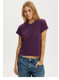 Woman wearing purple short-sleeve t-shirt and blue jeans