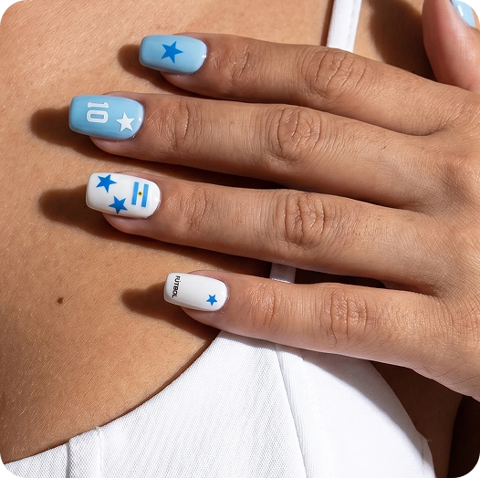 Close-up of a hand with light blue and white manicured nails featuring star designs, an 'H' initial, a '10' jersey number, and a small soccer text detail.