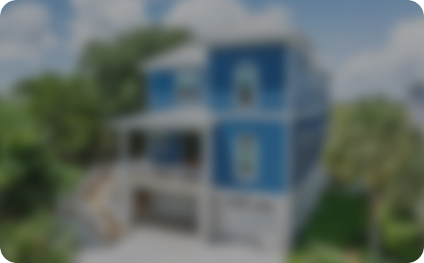 Blue and white elevated house with exterior stairs, shown intentionally blurred.