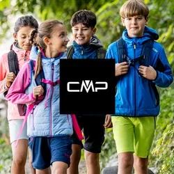 Quattro bambini con zaini che camminano su un sentiero nel bosco accanto a una recinzione di legno, circondati da alberi verdi e fogliame.