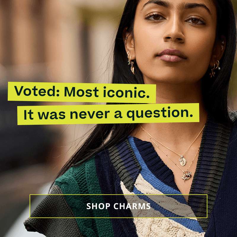 Model in dangling pendant chains & ear stacks with charms. Voted: most iconic. Click here to shop charms