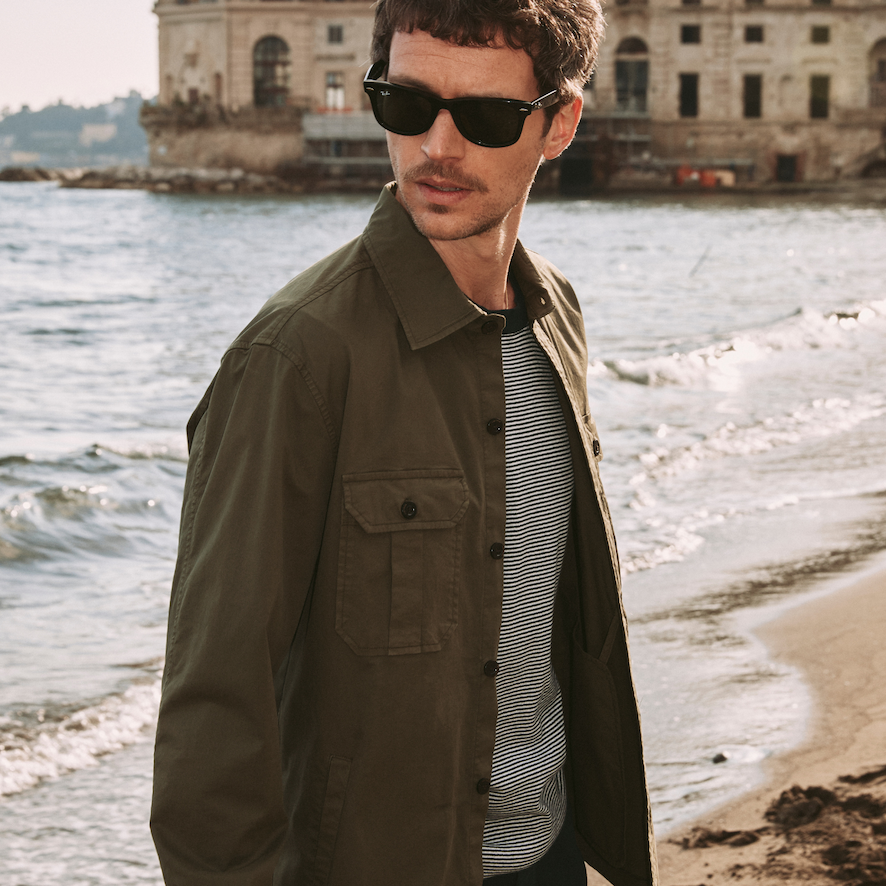 man at the beach with green cotton overshirt 