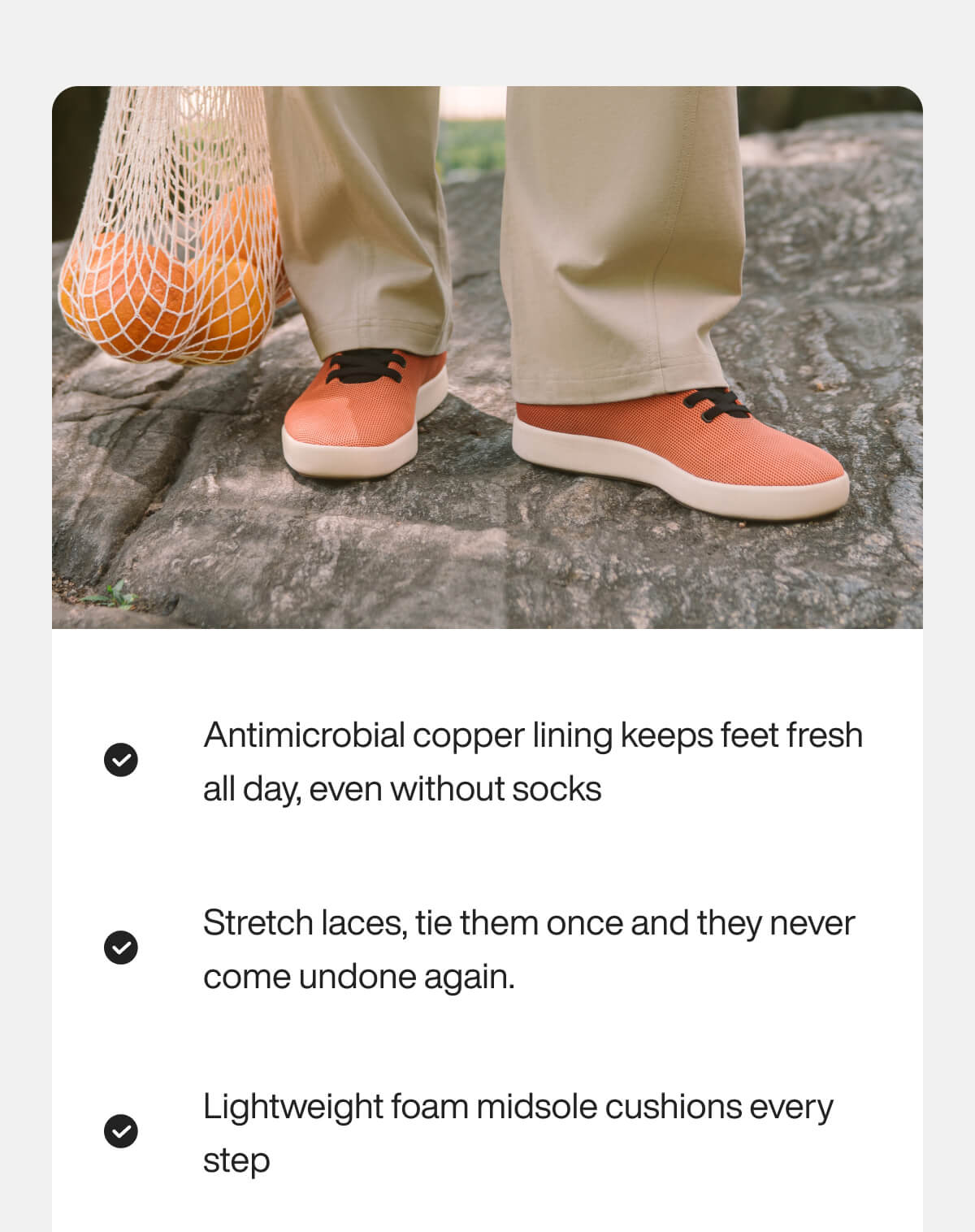 "Orange shoes with stretch laces on stone, paired with beige pants. Mesh bag with oranges. Features listed: antimicrobial, foam."