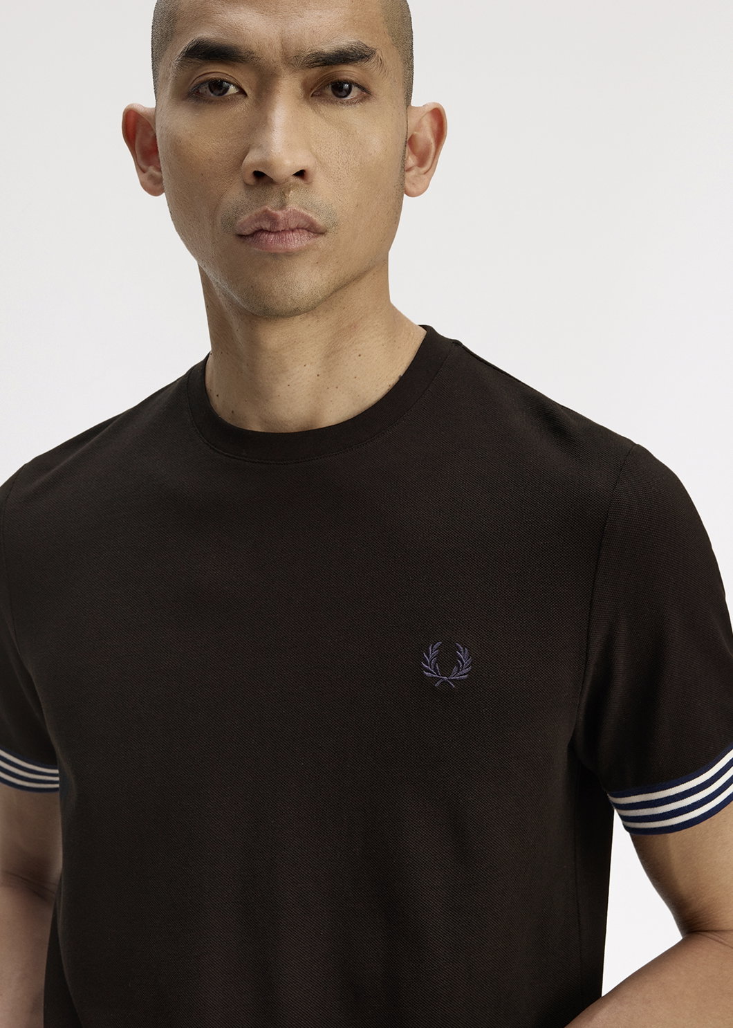 Male model wearing a Fred Perry Striped Cuff T-Shirt in Black