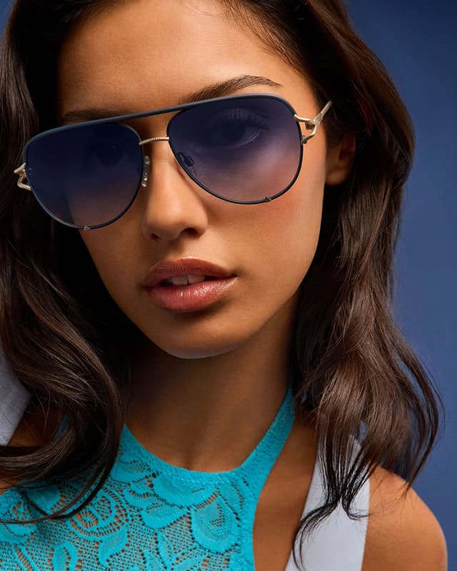 Image of woman wearing navy blue aviator sunglasses looking at the camera