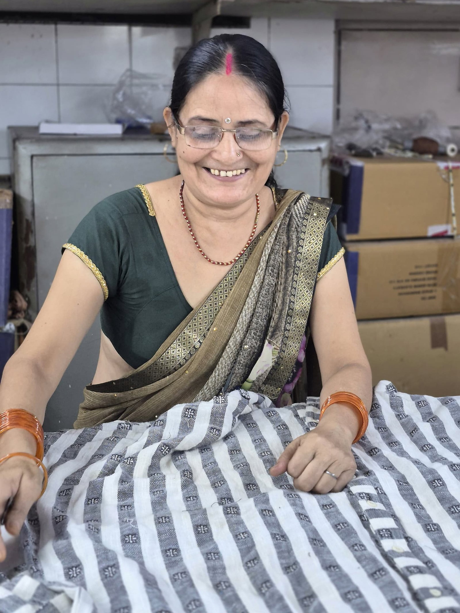 smiling woman checking buttons on garment