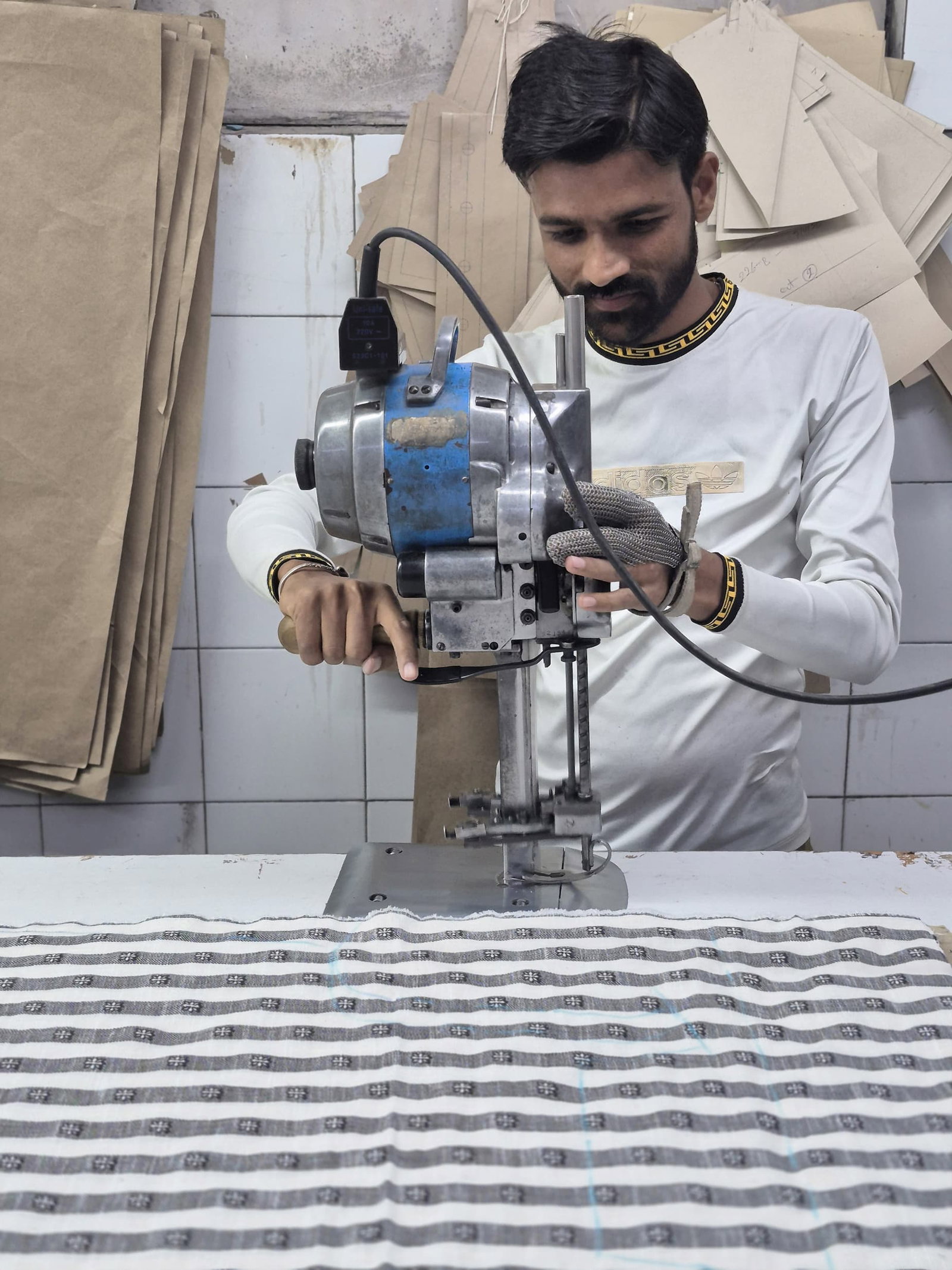 man cutting striped textile