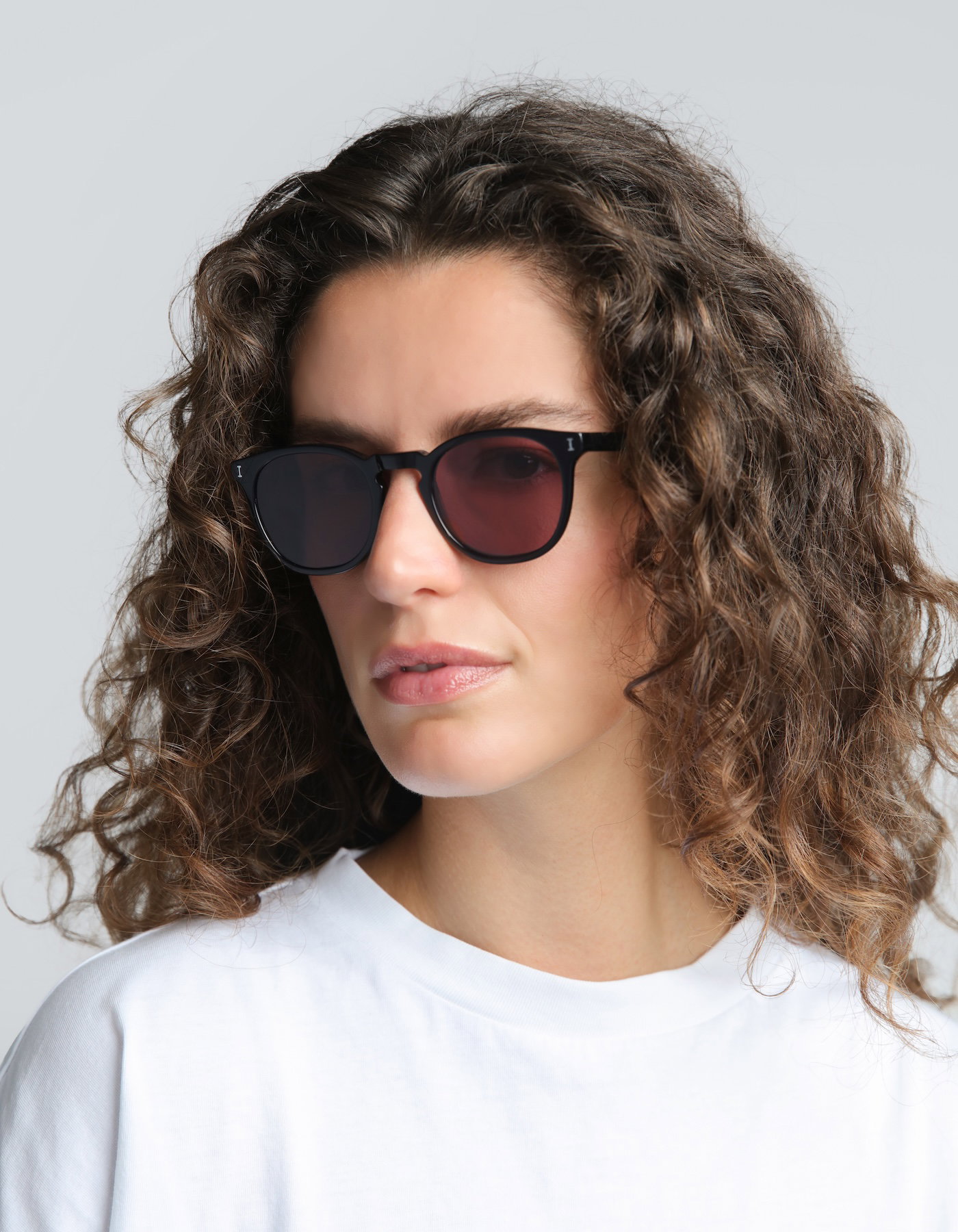 Woman with curly hair wearing Eldridge in Black with Plum
