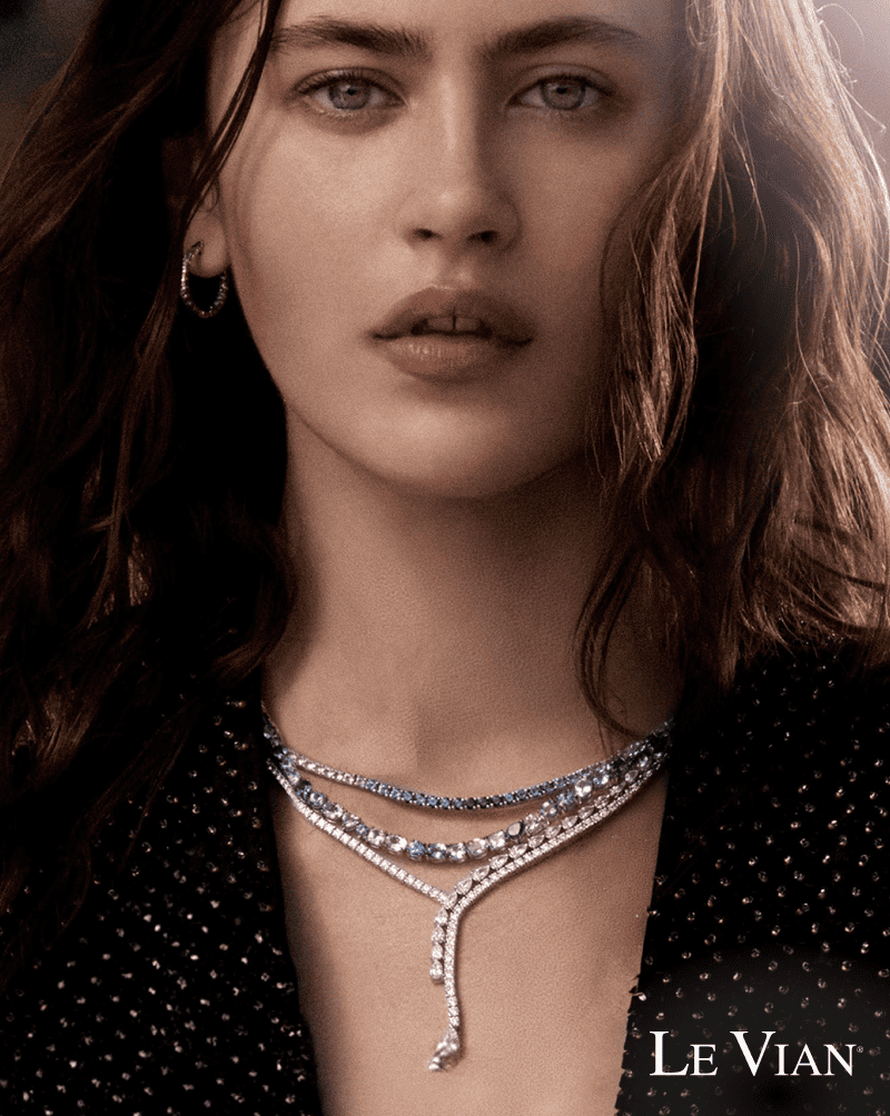Model wearing layered sapphire and diamond necklaces. 