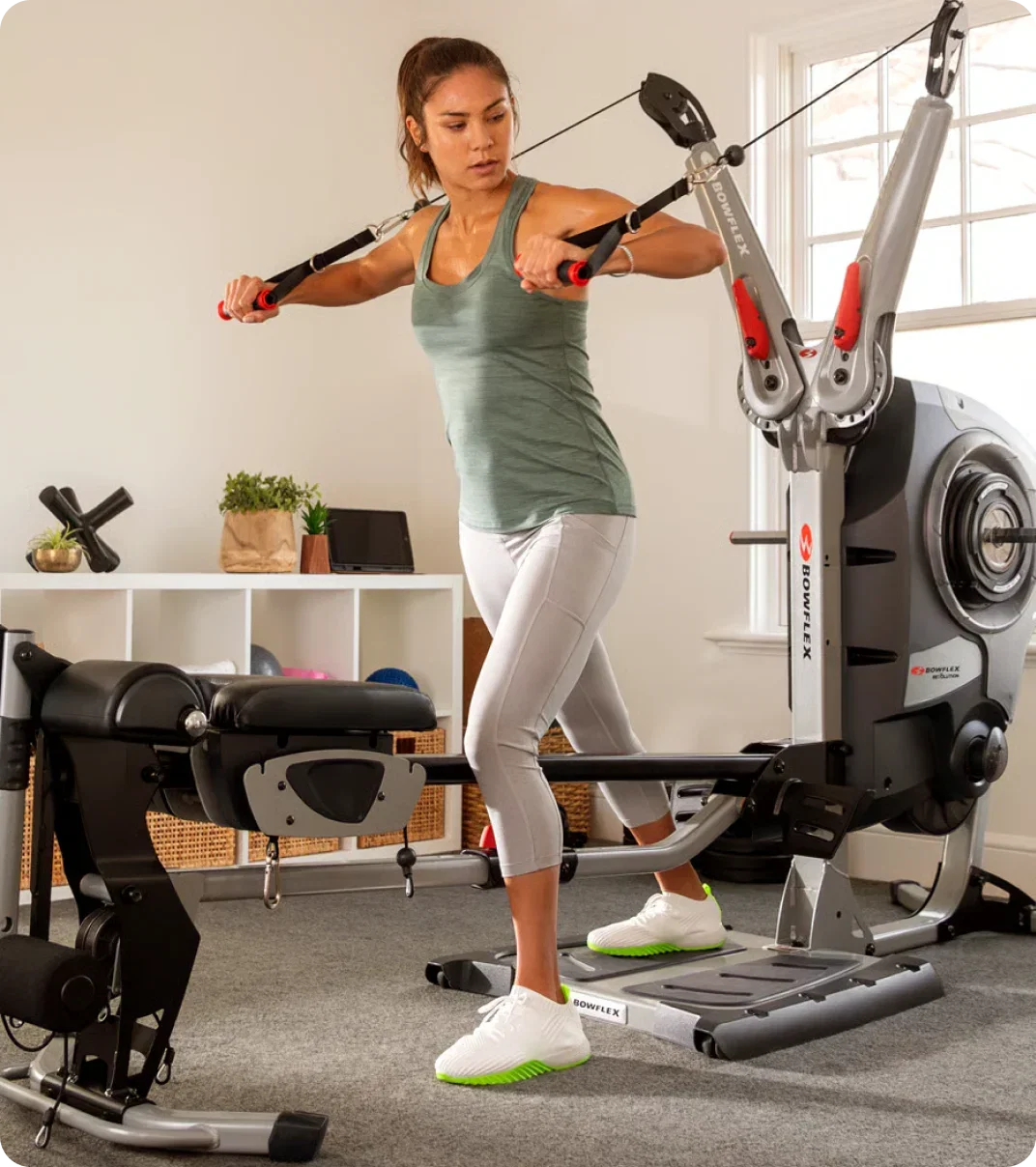 Woman doing strength training with Bowflex equipment.