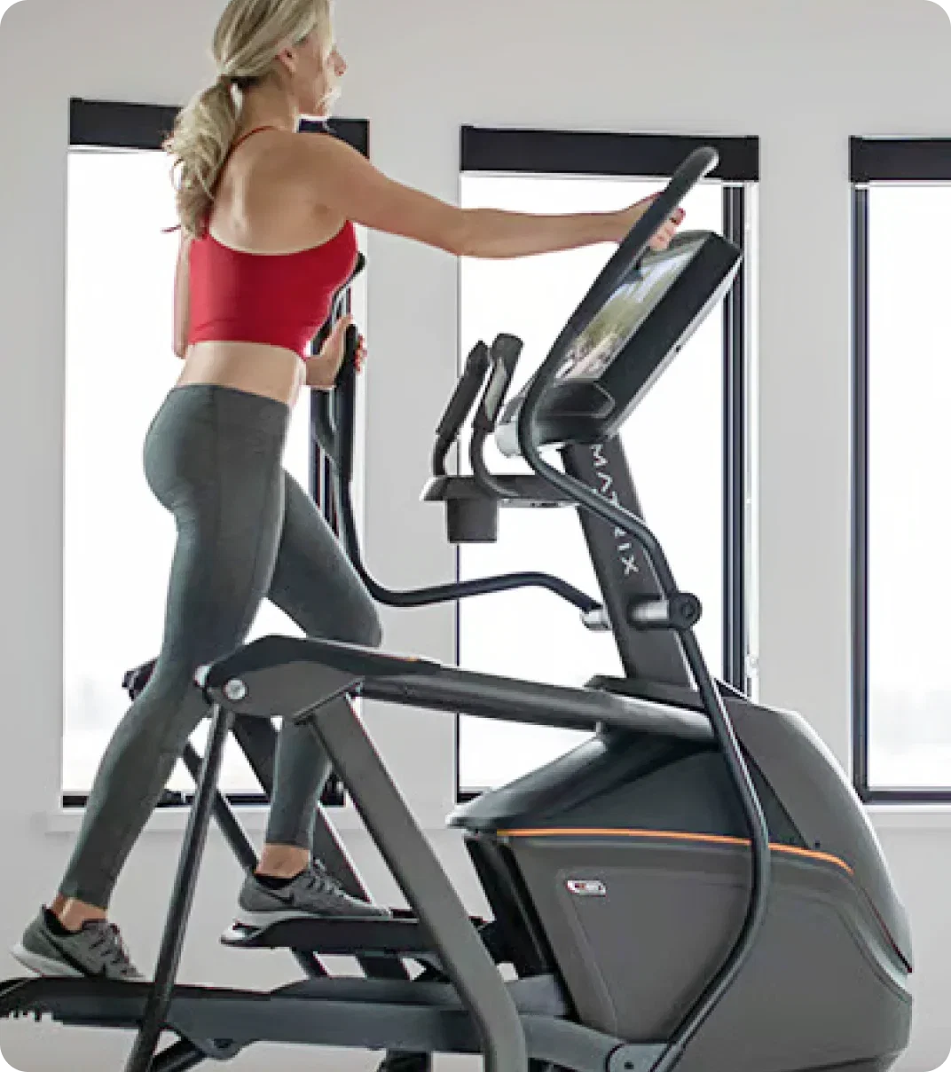 Woman exercising at home on a Matrix Ascent Trainer.