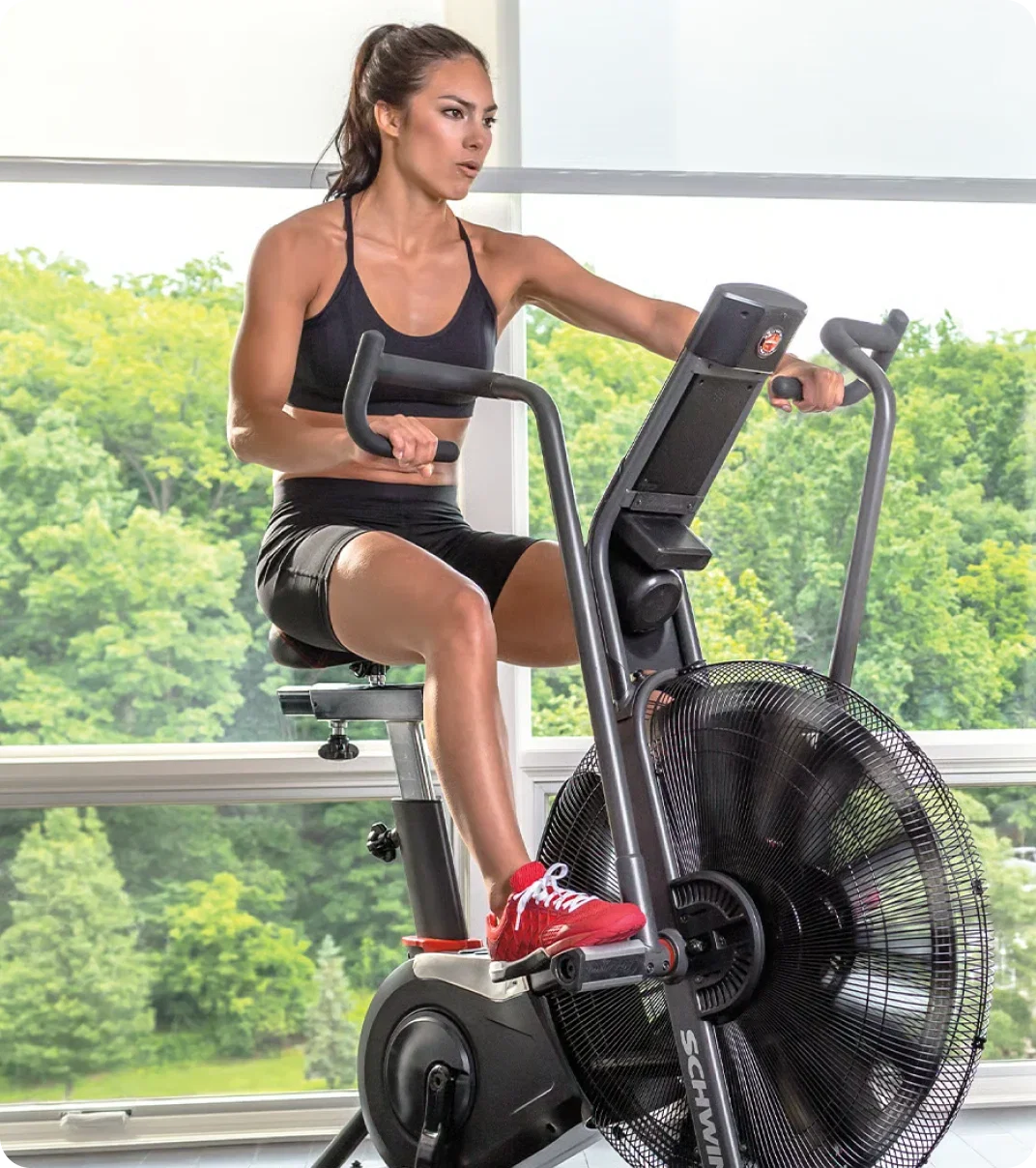 Woman training at home on a Schwinn bike.