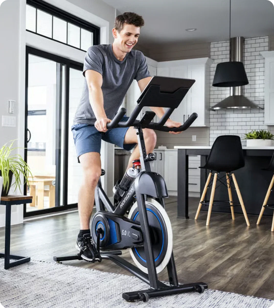 Man exercising at home on a Horizon indoor bike.