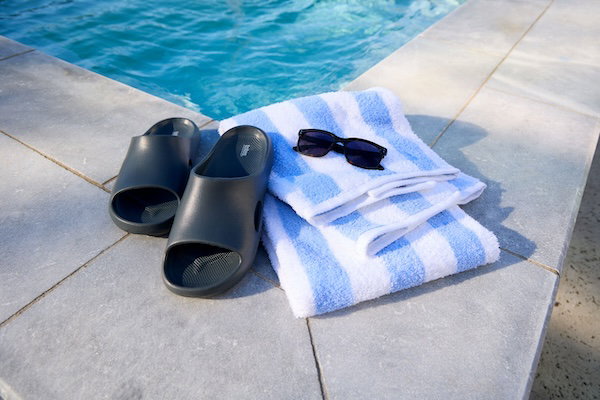 Men's sandals sit by a pool