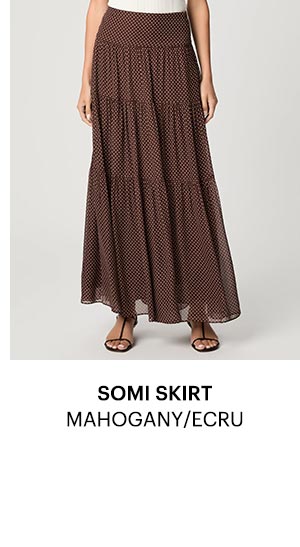 An image of a woman's legs wearing a brown maxi skirt with ecru polka dots.