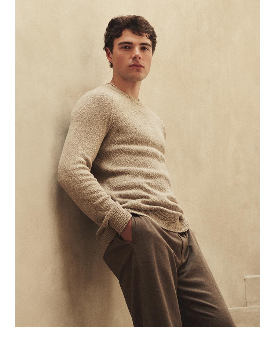 An image of a man wearing a beige sweater and brown patns.
