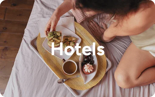 Person eating food on a hotel bed