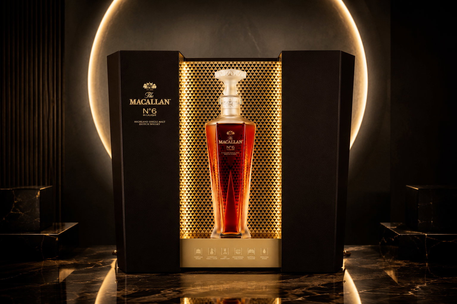 The Macallan No.6 crystal decanter of amber single malt whisky in a gold-lit luxury presentation box on a marble surface