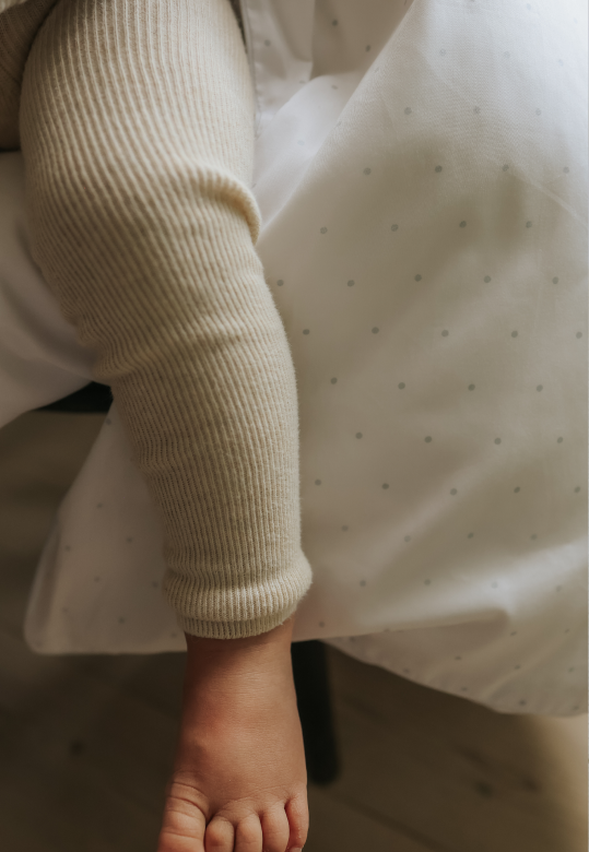 baby's leg hanging over blanket