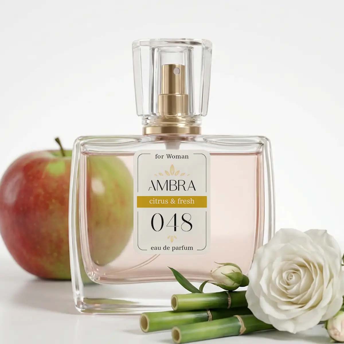 Glass bottle of AMBRA 048 'citrus & fresh' eau de parfum for women, styled with apple, white rose and bamboo accents