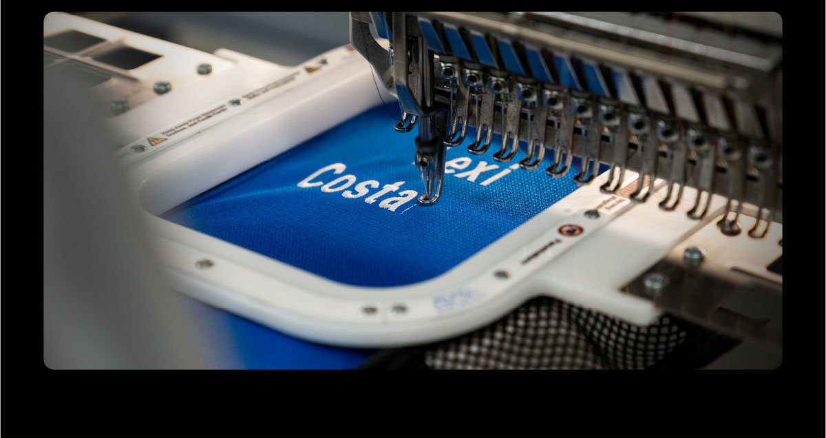 Picture of a custom bag being embroidered, adding a name.