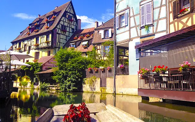 Canal de la Petite Venise de Colmar con casas de entramado de madera reflejadas en el agua