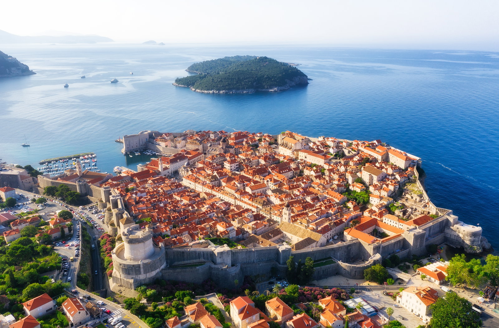Vista aérea de Dubrovnik con sus murallas envolviendo los tejados de terracota del casco antiguo junto al Adriático