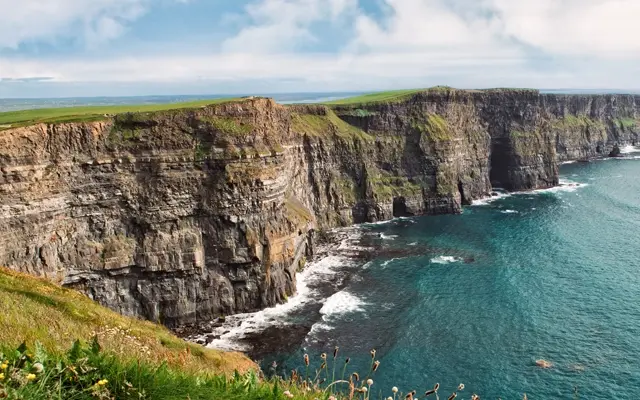 Los Acantilados de Moher alzándose sobre el Atlántico con sus paredes verticales cubiertas de hierba