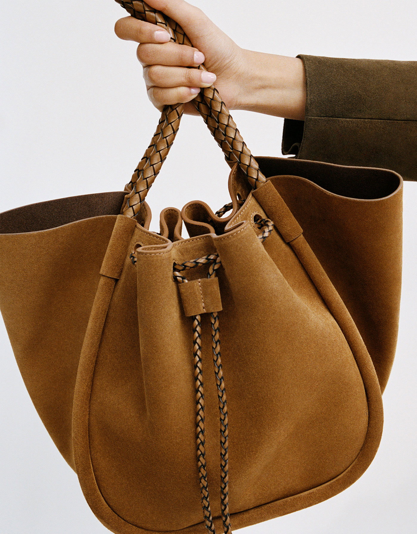 Cropped image of model holding the Large Ruched Tote in Suede and Braided Calf in Hazelnut