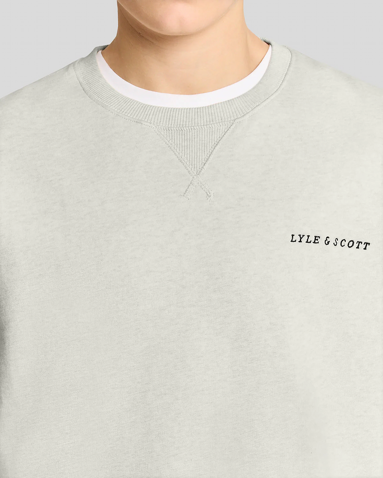 Man wears Heavyweight Script Sweatshirt in Ice Cream Marl