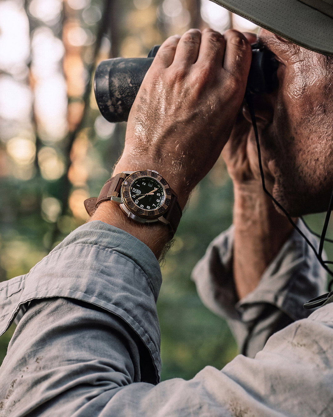 Man sitting in the gym with a backwards hat with watch on wrist