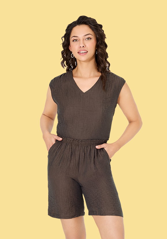 Damenmodel trägt braune Bluse mit V-Ausschnitt und braune Shorts mit Lyocell, Vorderansicht.