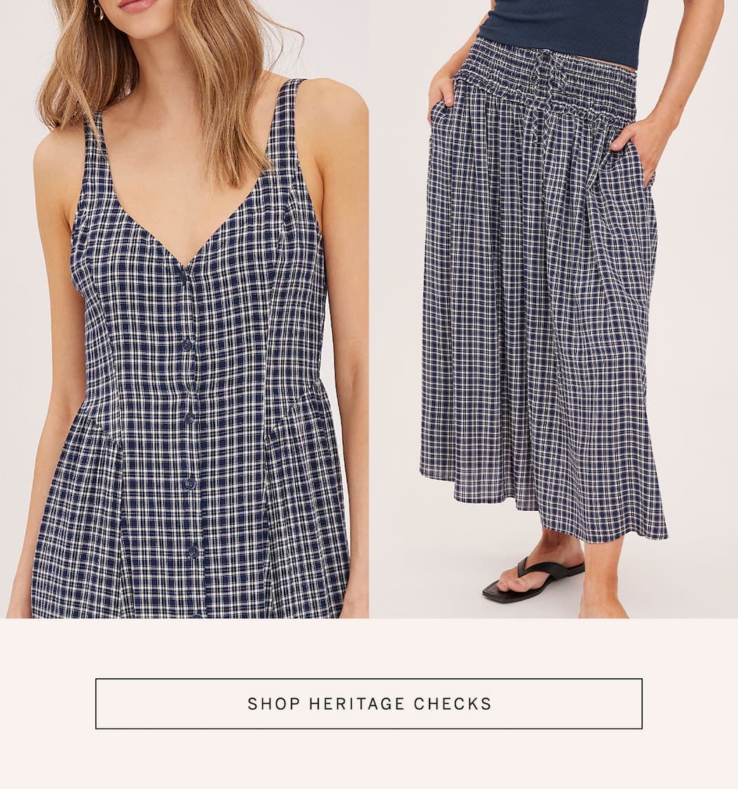 Model wears a navy check dress beside a matching check midi skirt. “Shop Heritage Checks.”