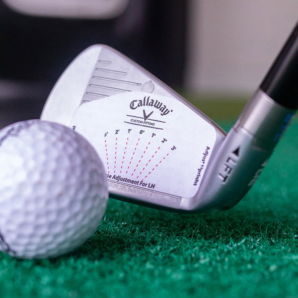 Test golf club addressing golf ball