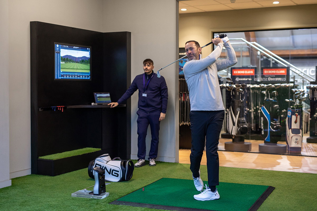 Man swinging golf club during custom fitting session