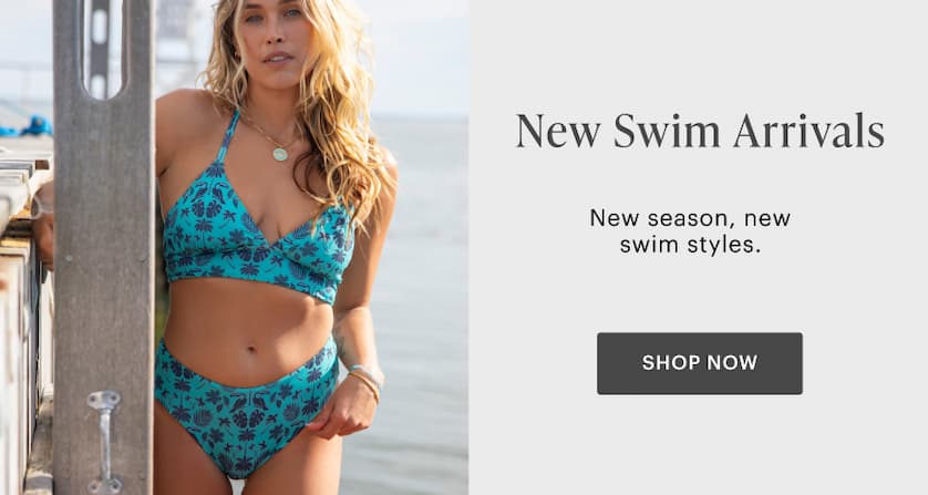 New Swim Arrivals  - Woman in Dahlia Top and Erin Bottom standing by boardwalk with ocean in background. 