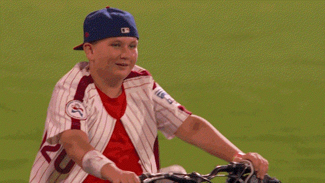 An animated gif of children interacting with All-Stars as fireworks go off overhead