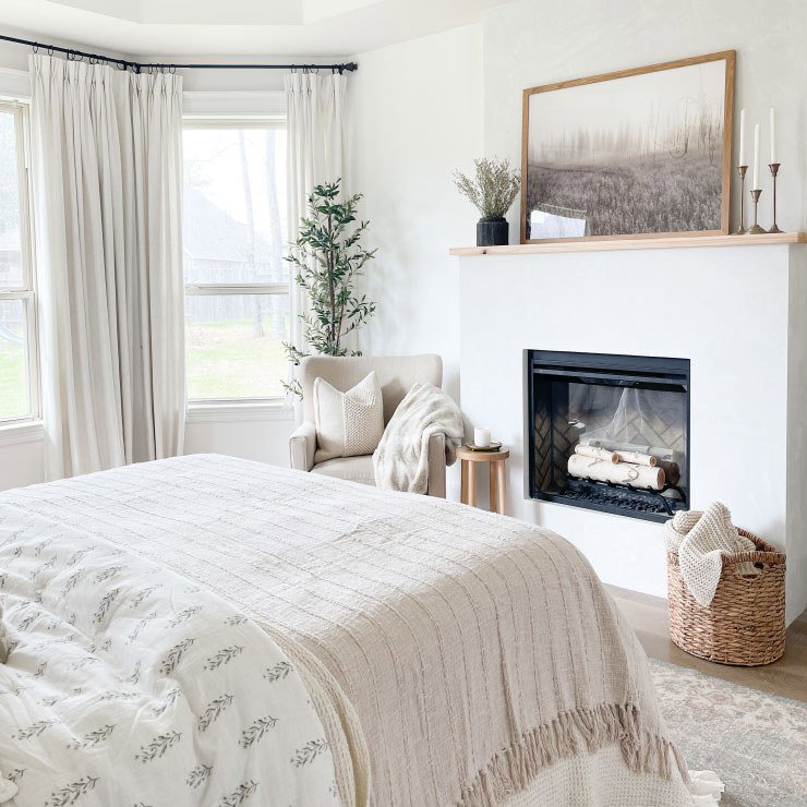 Cozy bedroom with fireplace and armchair.