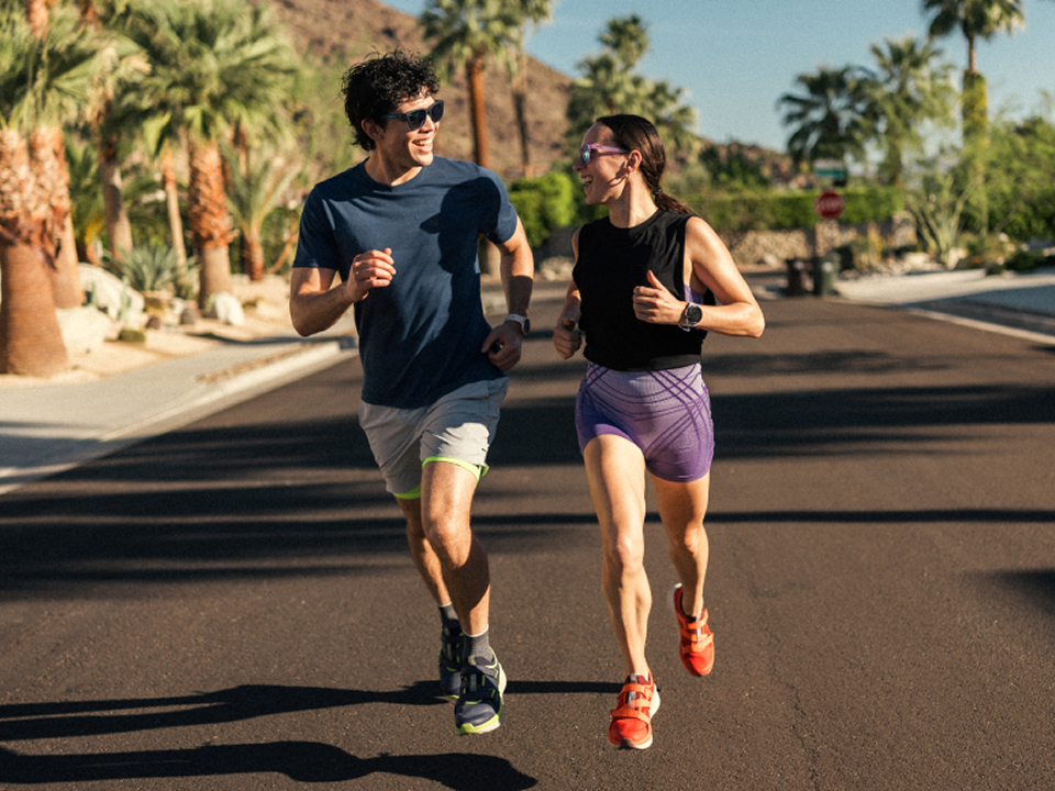 Two people smiling while running in the road on a sunny day, wearing the Aventrail R2T shoes & sandals.