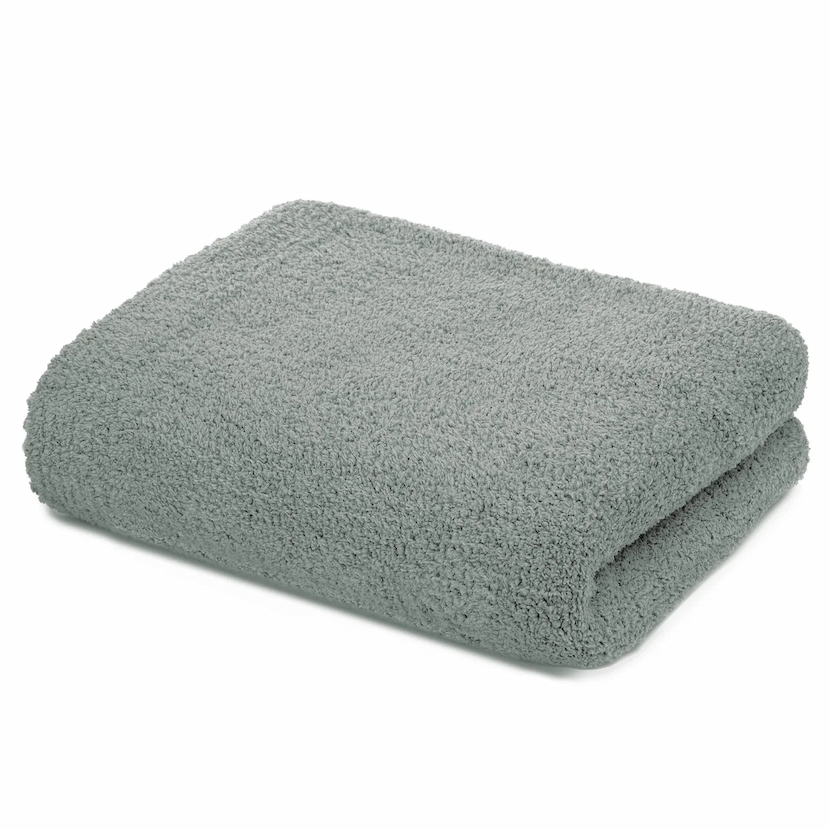 Folded solid mist green Kashwere throw with a plush, cozy texture, displayed on a white background.