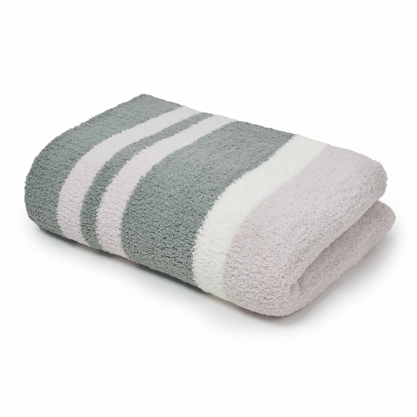 Folded Kashwere throw featuring wide stripes in mist green, bone, and creme, shown on a white background.